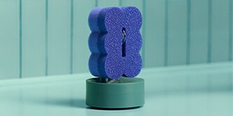 Brite by Scotch-Brite™ 2-seitiger Reinigungsschwamm auf einem Ständer beim Waschbecken.
