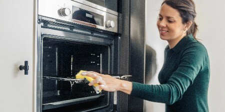 Frau beim Reinigen des Ofens mit Scotch-Brite® Power Classic Reinigungsschwamm
