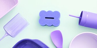 Brite by Scotch-Brite™ violette 2-seitige Reinigungsschwämme, präsentiert zusammen mit pastellfarbenen Küchengeräten auf der Küchenarbeitsplatte.
