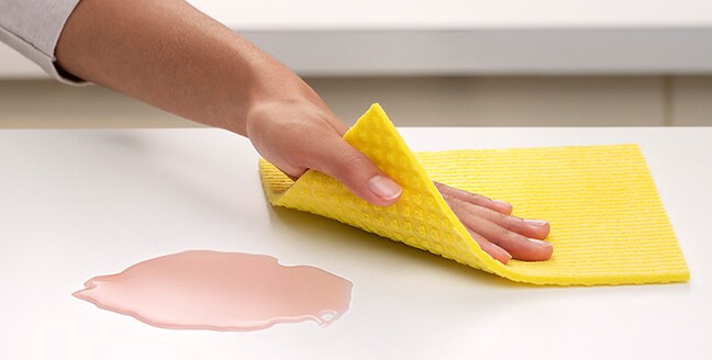 Reinigung der Arbeitsplatte mit Scotch-Brite® Schwammtuch
